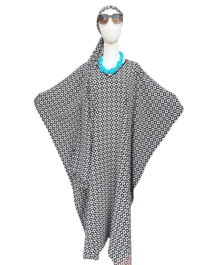 Mannequin wearing a black and white patterned poncho with sunglasses on a white background
