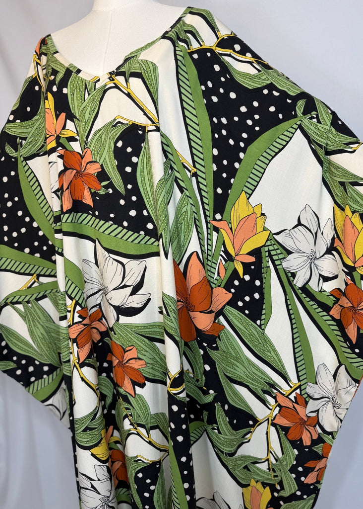 Mannequin wearing a floral patterned shirt with green, orange, and white colors.
